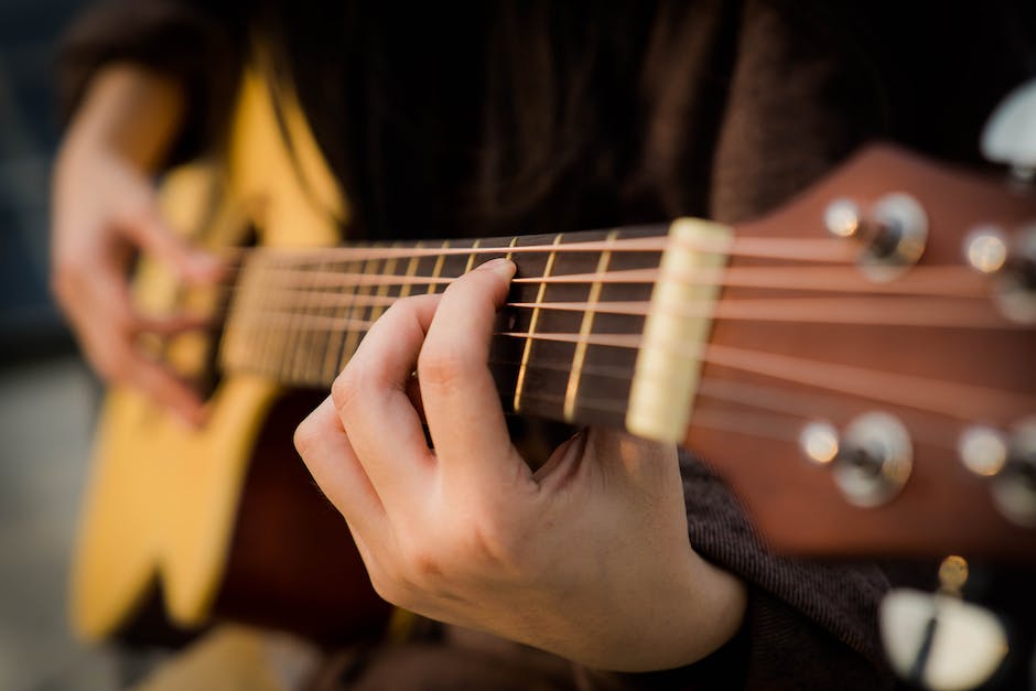 Image of a microphone positioned near a guitar, capturing the sound waves in the air