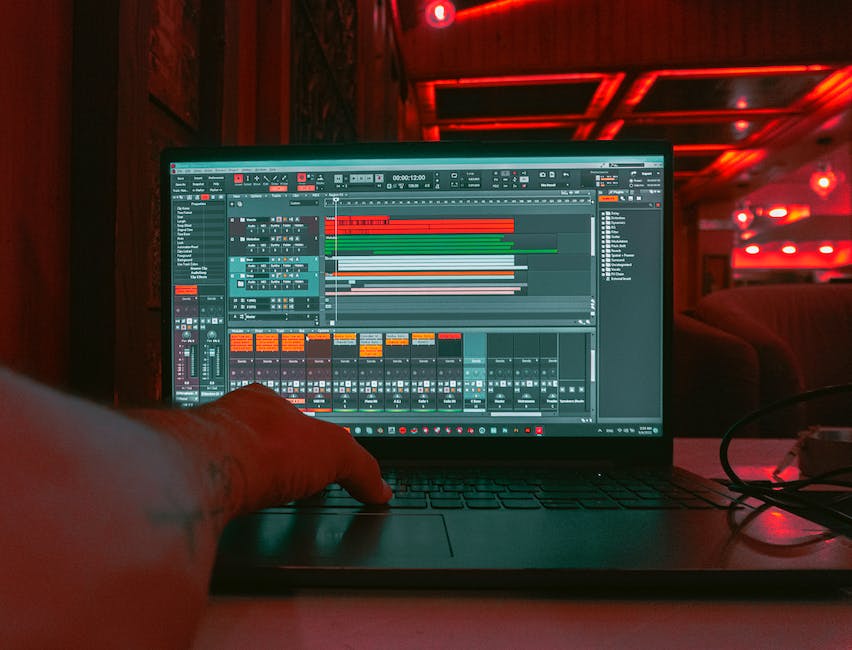 Image of a person sitting at a computer, creating music with a Digital Audio Workstation